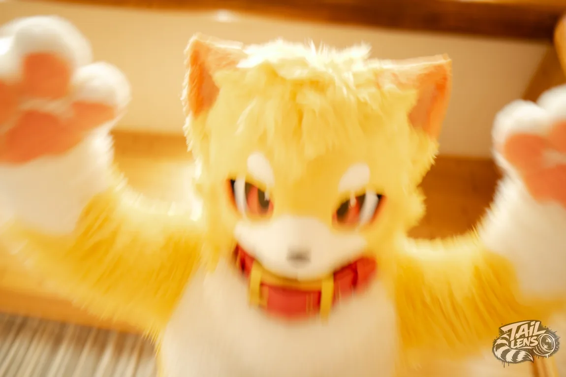 暖色の室内で両手を広げる黄色い着ぐるみキャラクター